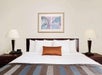 One king bed, a desk and chair inside a guest room.