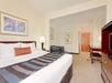 One king bed, a desk and chair inside a guest room.