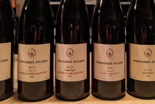 Five bottles of Descendant Cellars wine labeled as "Hale" from different years, including 2011, 2012, and 2014, are lined up in a row on a countertop.