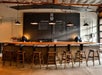 A bar with wooden stools and a large chalk board and low lighting at Lobo Hills near Seattle, Washington.
