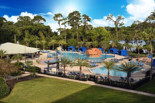View of the outdoor pool area and the lake at Wyndham Garden Lake Buena Vista Disney Springs Resort.