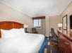 One king bed, a work desk, chair and an armchair inside a non-smoking room.