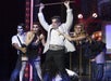 Two men in suits and women in sexy black dresses all in zombie makeup performing on stage at Zombie Burlesque in Las Vegas.