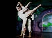 A man and woman in zombie makeup and white costume dancing gracefully on stage at Zombie Burlesque in Las Vegas.