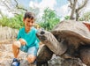 A boy with a giant tortoise at ZooTampa at Lowry Park in Tampa, FL.