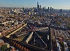 An aerial view of the Eastern State Penitentiary with numerous surrounding buildings, showcasing an urban landscape with a clear view of the skyline against a backdrop of the sky.
