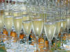 Multiple champagne glasses filled with bubbly wine on a floral tablecloth.