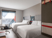 Two queen beds, work desk and large window inside a non-smoking room at avid hotels Fort Mill - Amusement Park, an IHG Hotel, SC.