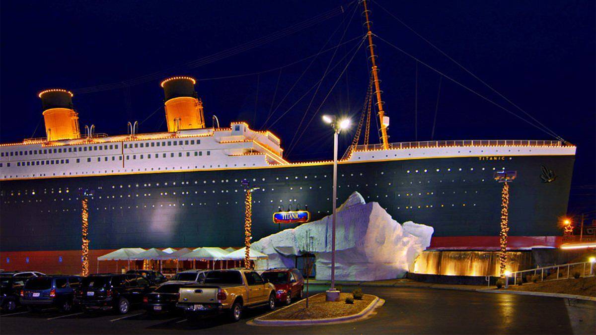 Night view of the exterior of the Titanic Museum in Branson, Missouri, with a replica of the Titanic ship and iceberg.