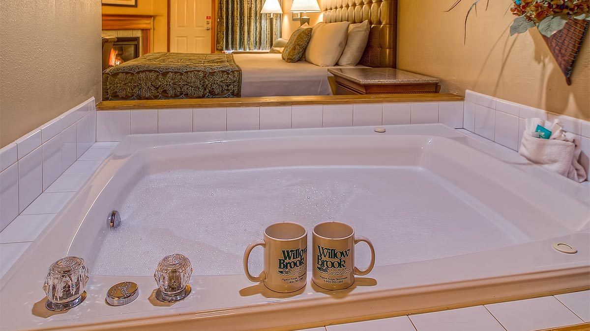 close up of jetted tub inside of the Willow Brook Lodge with two mugs on ledge in Pigeon Forge, Tennessee, USA