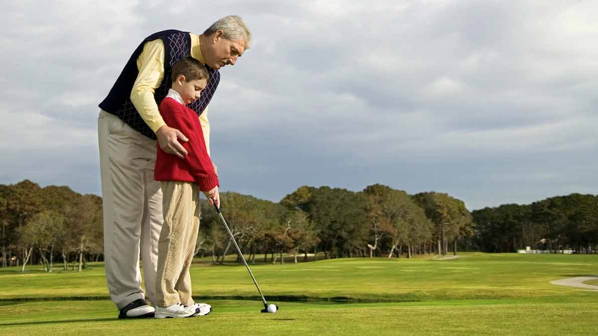 Grandpa and Grandson in blue shirts Playing Mini Golf