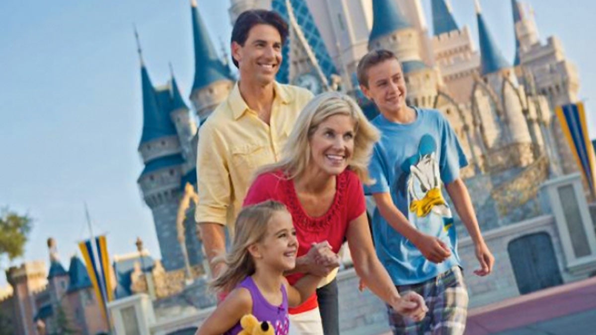 close up of family of four in front of Cinderella's Castle at Walt Disney World Magic Kingdom in Orlando, Florida, USA