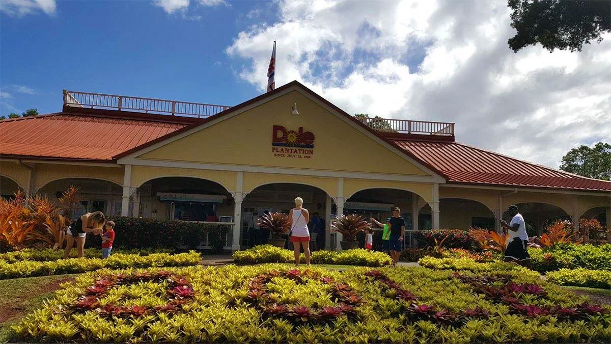 people standing around ground exterior view of the Dole Plantation building in Oahu, Hawaii, USA
