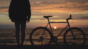 Person and Bike Silhouette in front of ocean at Dusk
