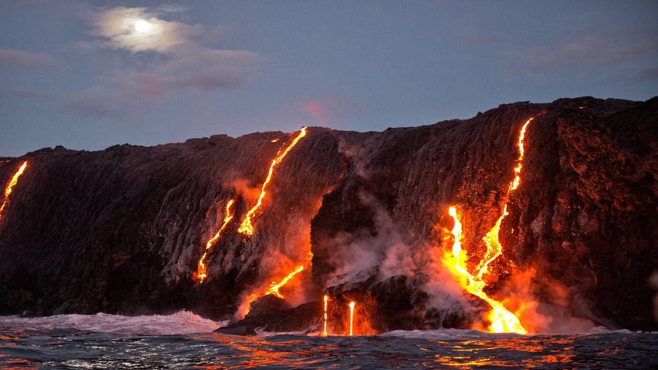 Lava Flowing over cliffs into the ocean at Hawaiian Volcanoes National Park - The Big Island, Hawaii, USA