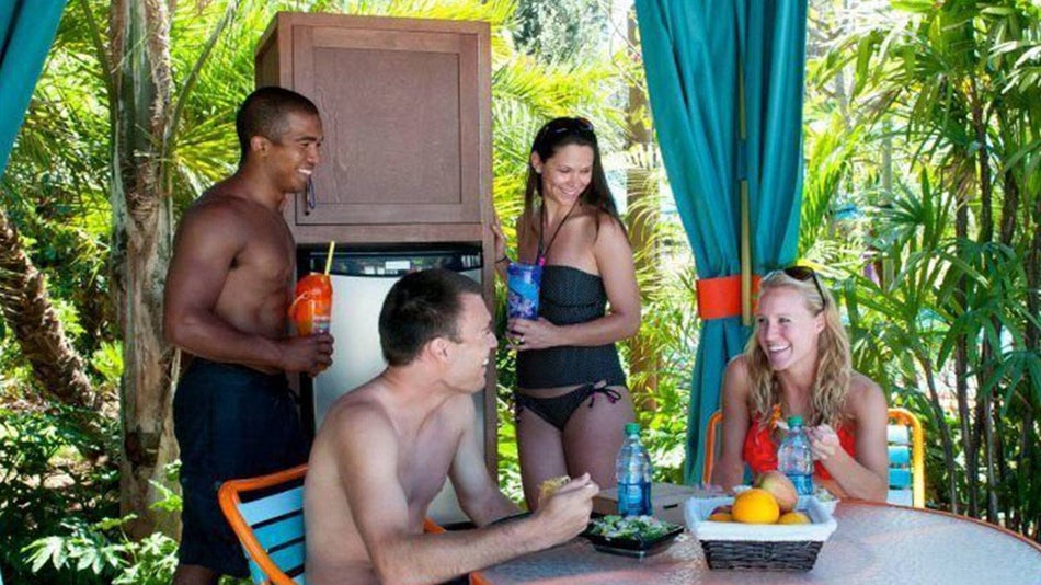 Friends eating and drinking in a Cabana at Aquatica San Diego - San Diego, California, USA