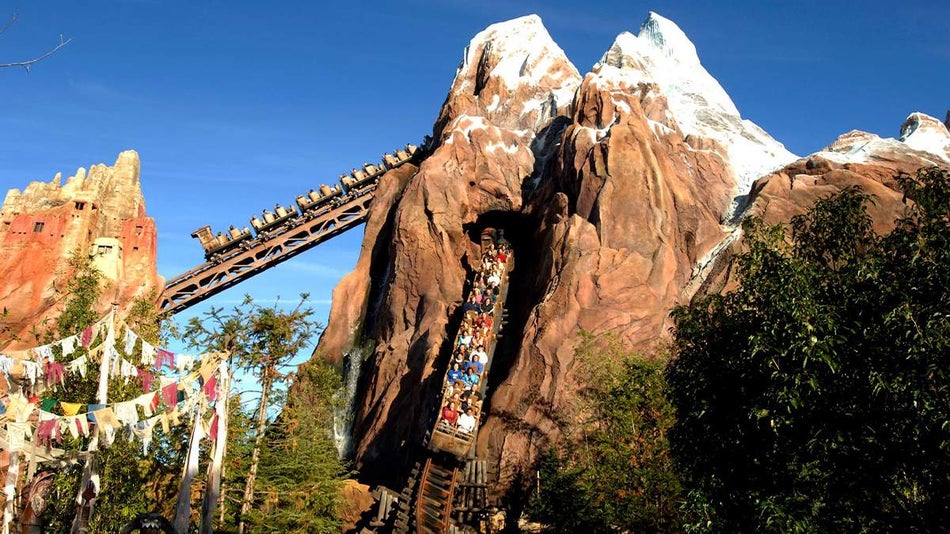 Lake in foreground and people riding Expedition Everest at Walt Disney World's Animal Kingdom - Orlando, Florida, USA