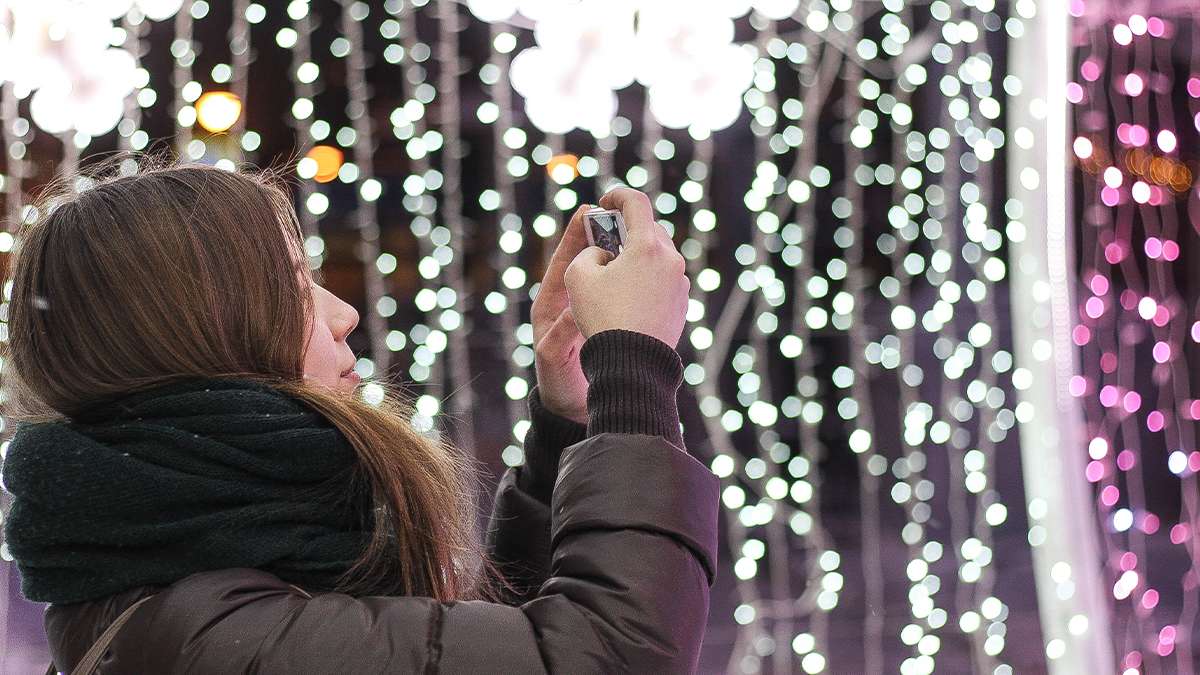 Woman Taking Photo of Christmas Lights