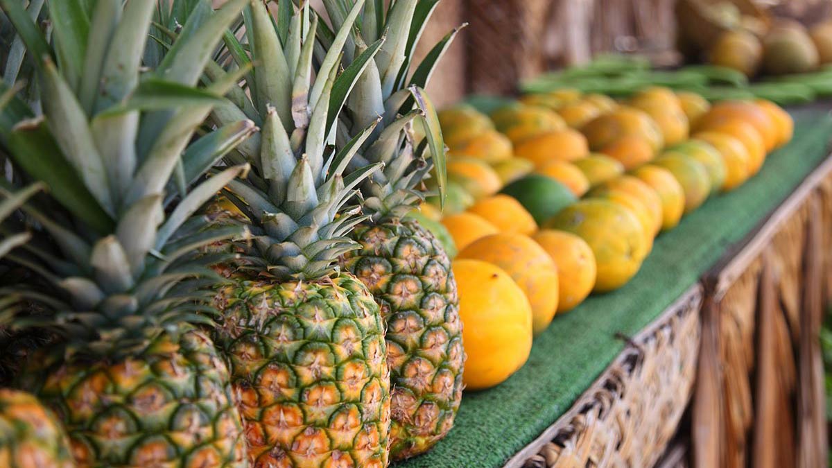 close up of pineapple and oranges in a fruit market