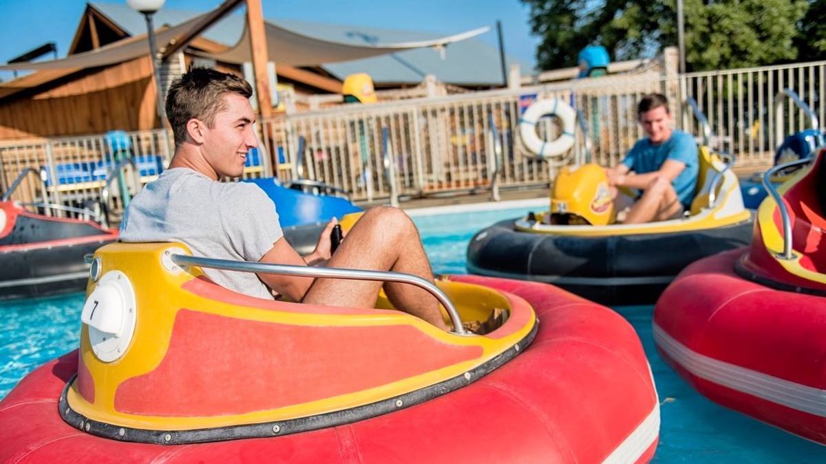two teenagers on water bumper cars at The Track Family Fun Parks in Branson, Missouri, USA