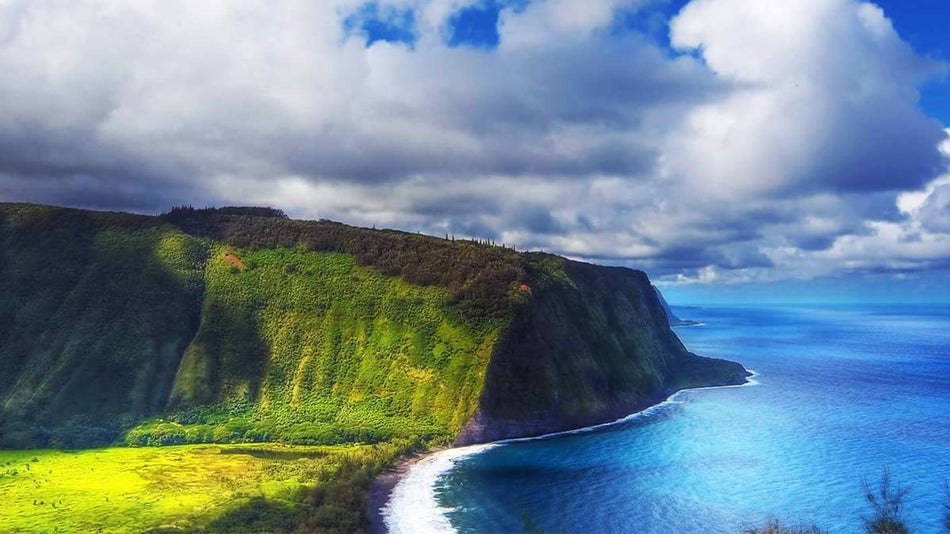 aerial view of turquoise water and green mountains with a blue sky at Waipi'o Valley in Big Island, Hawaii, USA