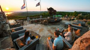 family sitting around fire pit at sunset at the Buffalo Bar at Top of the Rock in Branson, Missouri, USA