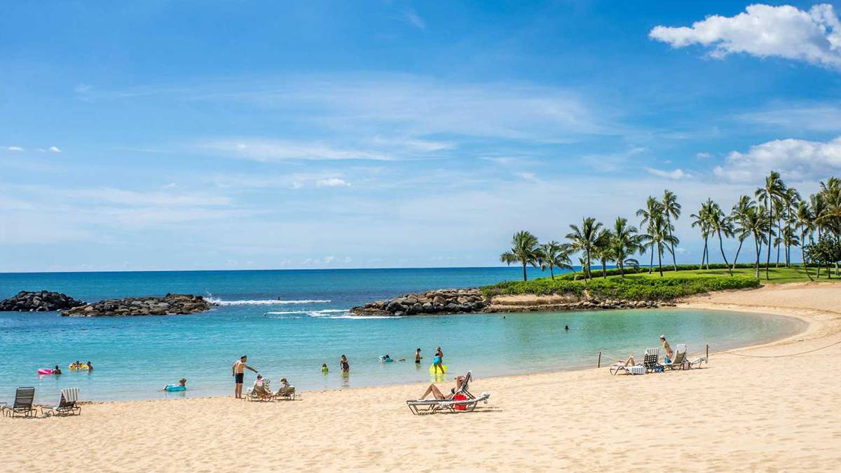 people relaxing on the sandy beach on a sunny day in Oahu, Hawaii, USA