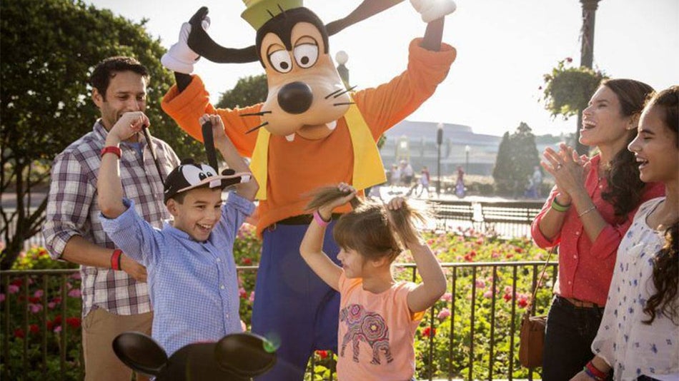 family playing with Goofy character at Disneyland in Los Angeles, California, USA