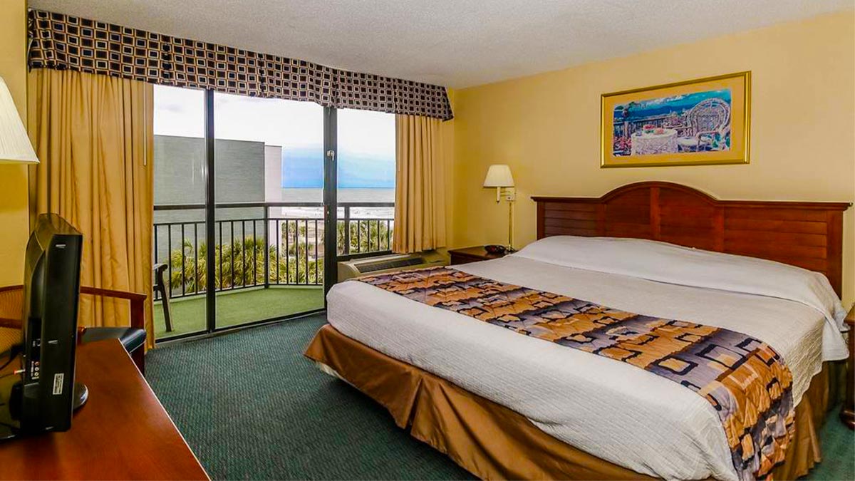 interior view of bed with balcony overlooking the beach at The Patricia Grand by Vacasa in Myrtle Beach, South Carolina, USA
