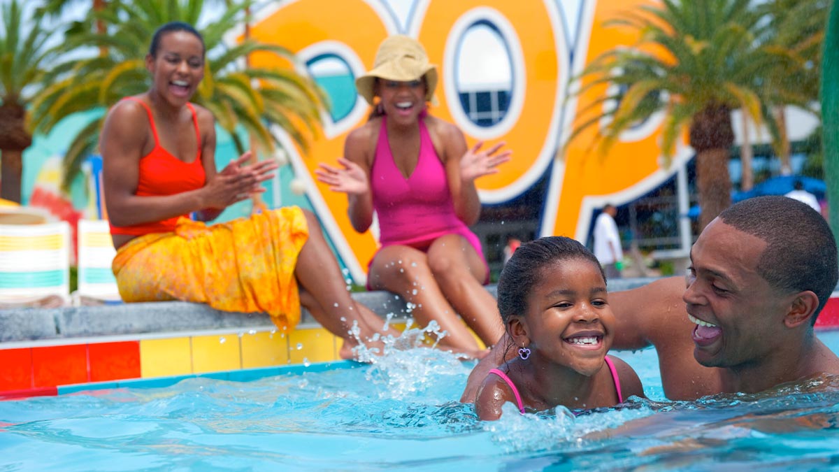 close up of young family splashing in swimming pool at Disney's Pop Century Resort in Orlando, Florida, USA