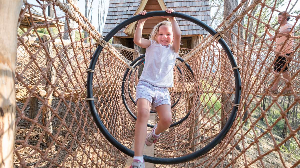 young girl playing on outdoor playground at Treehouse Village at Anakeesta in Gatlinburg, Tennessee, USA