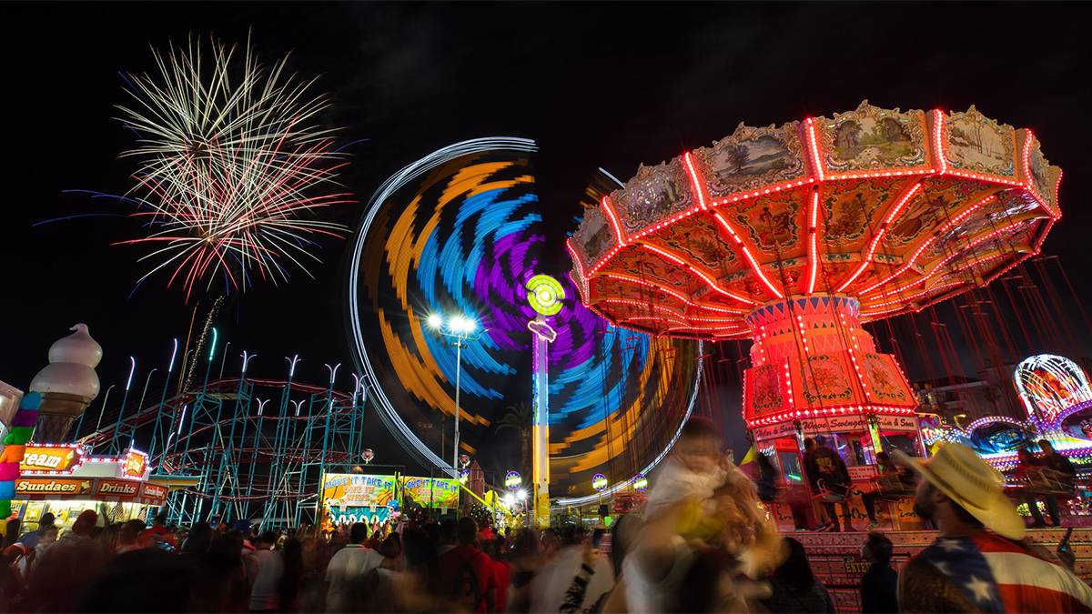 night view of blurred lights and fireworks over the San Diego, California, USA county fair
