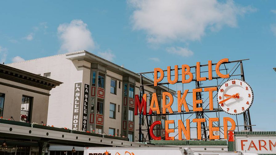 View looking up at the sign for Pike Place Market on a sunny day with a blue sky in Seattle, Washington, USA