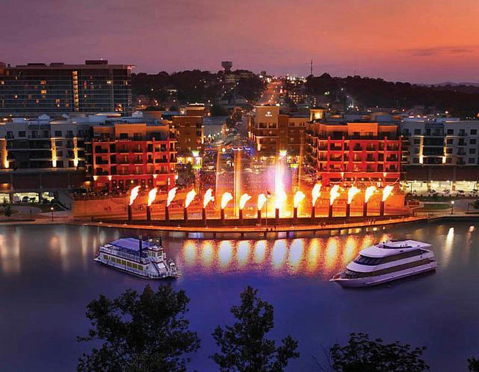 night view of the Fire and Ice show downtown at the Branson landing with boats parked on the water in front in Branson, Missouri, USA