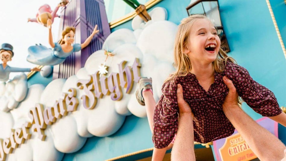 Girl Being Held up in front of the Peter Pan's Flight Sign at Walt Disney World - Orlando, Florida, USA