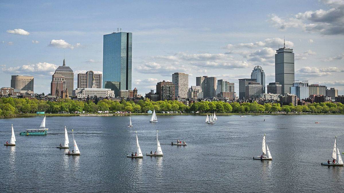 sailboats in harbor with skyline and downtown in the background in Boston, Massachusetts, USA