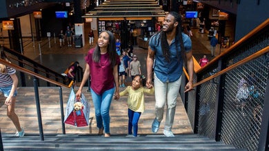 family in mall shopping together walking up stairs