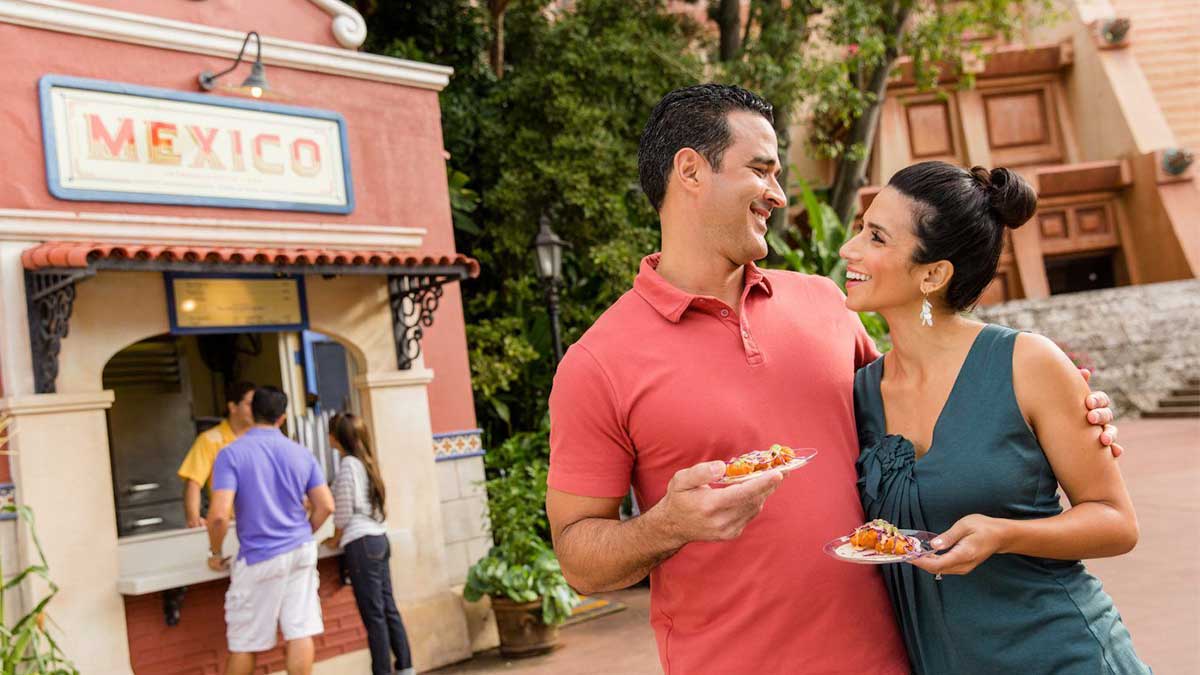 couple standing with food in epcot