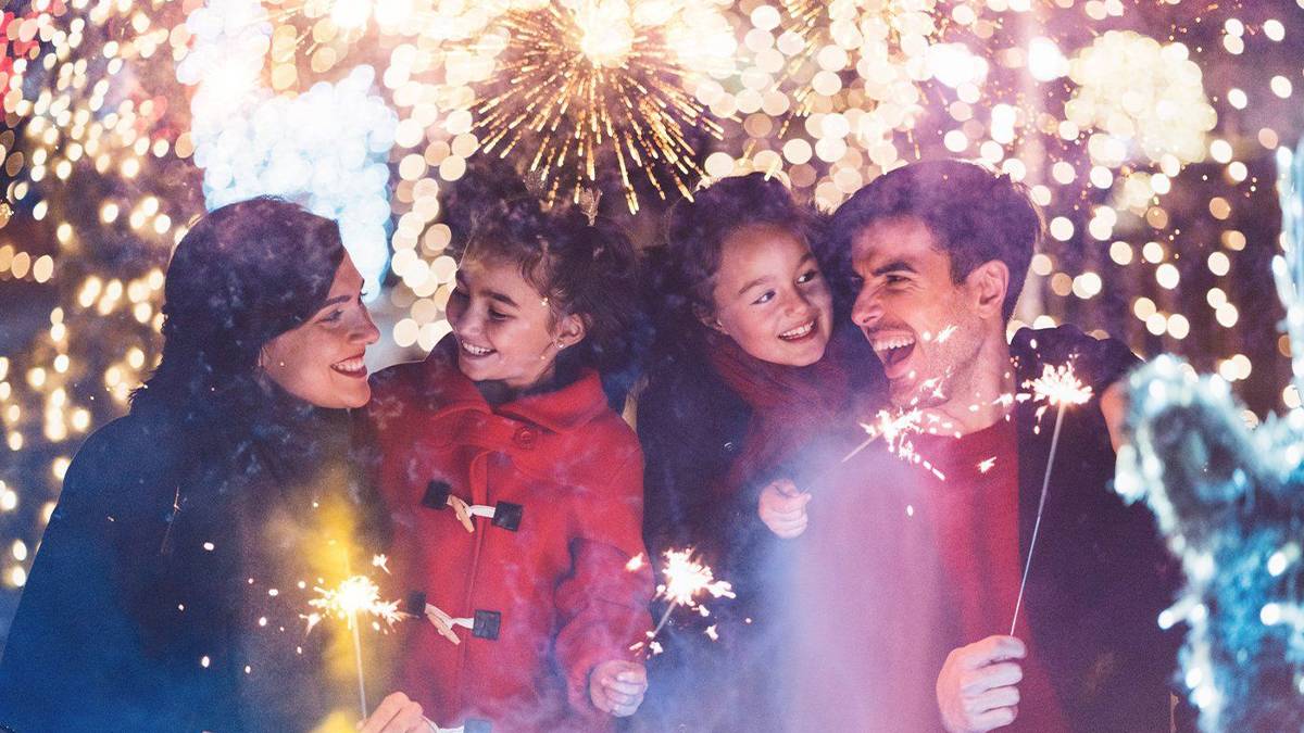 happy family with sparklers in winter coats