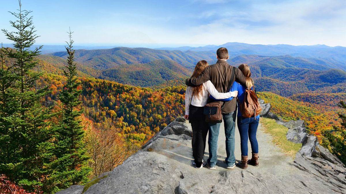 family standing together overlooking smoky mountains in fall in Gatlinburg, Tennessee, USA
