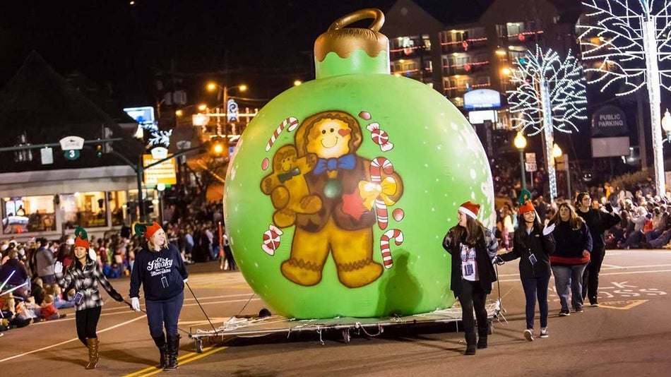 Volunteers carry a gigantic green Christmas ornament through downtown as part of Gatlinburg's Fantasy of Lights Christmas Parade
