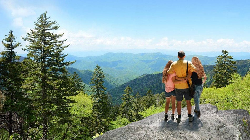 family standing at the top of a mountain taking in the view of the Great Smoky Mountains in Gatlinburg, Tennessee, USA