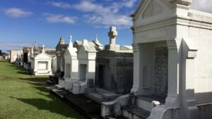 above ground vaults and mausoleum's in a row with green grass in New Orleans, Louisanna, USA