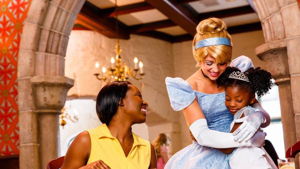 girl hugging cinderella with mom watching at disney world castle in Orlando, Florida, USA