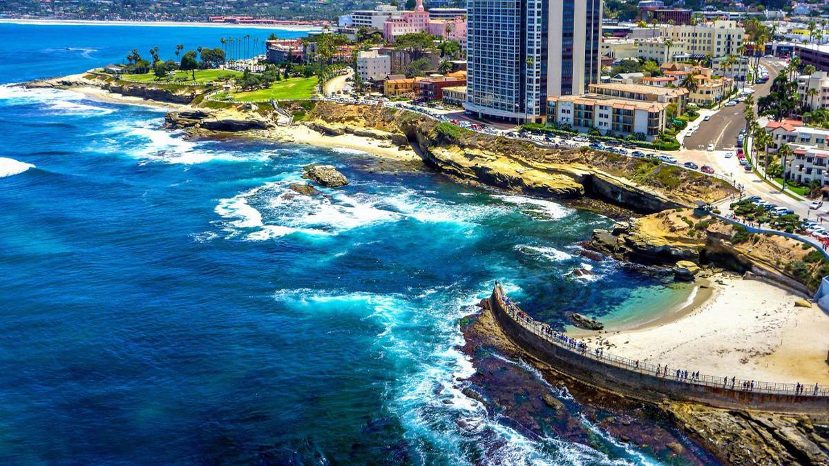 aerial drone view of La Jolla coastline with blue waters and hotels in San Diego, California, USA