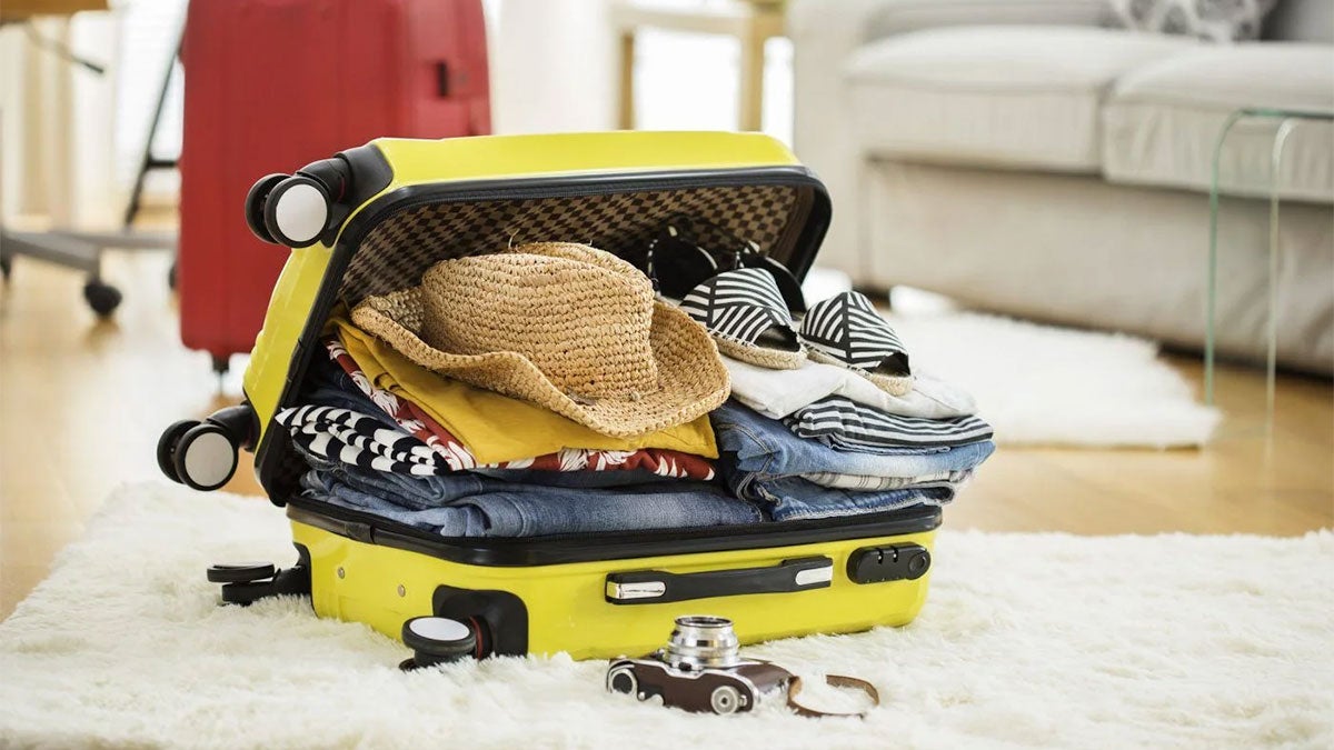 Yellow suitcase packed for travel