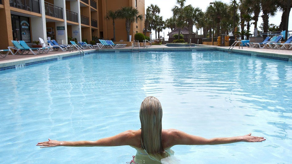 Woman Standing in Hotel Pool Looking at Scenery