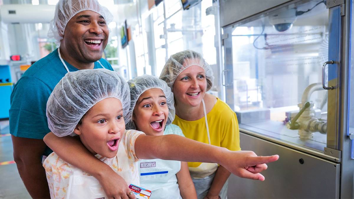 Family with hair nets on touring the factory at Hershey's Chocolate World
