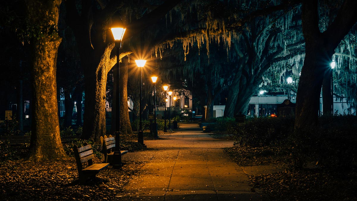 view of empty city sidewalk at night with street lights in Savannah, Georgia, USA