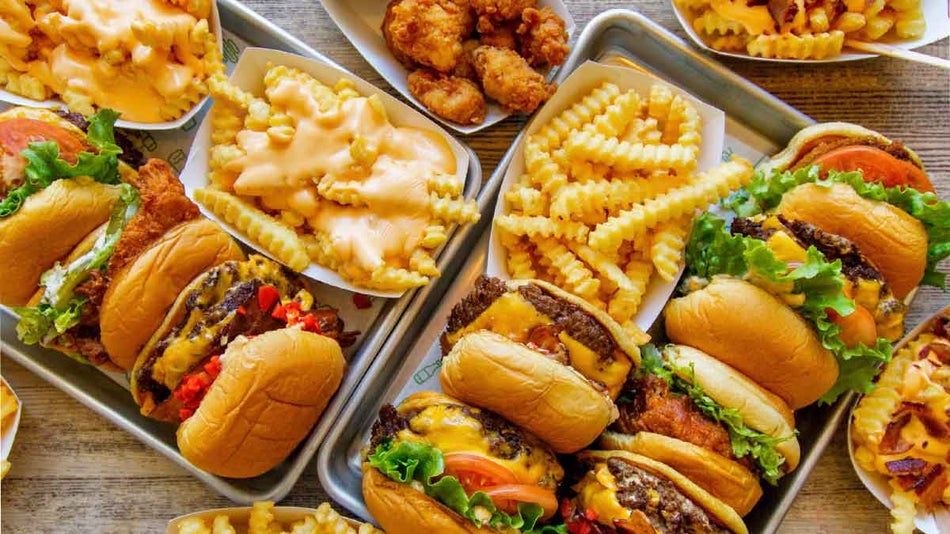 Close up of a table filled with burger and fries and chicken from Shake Shack in NYC, New York